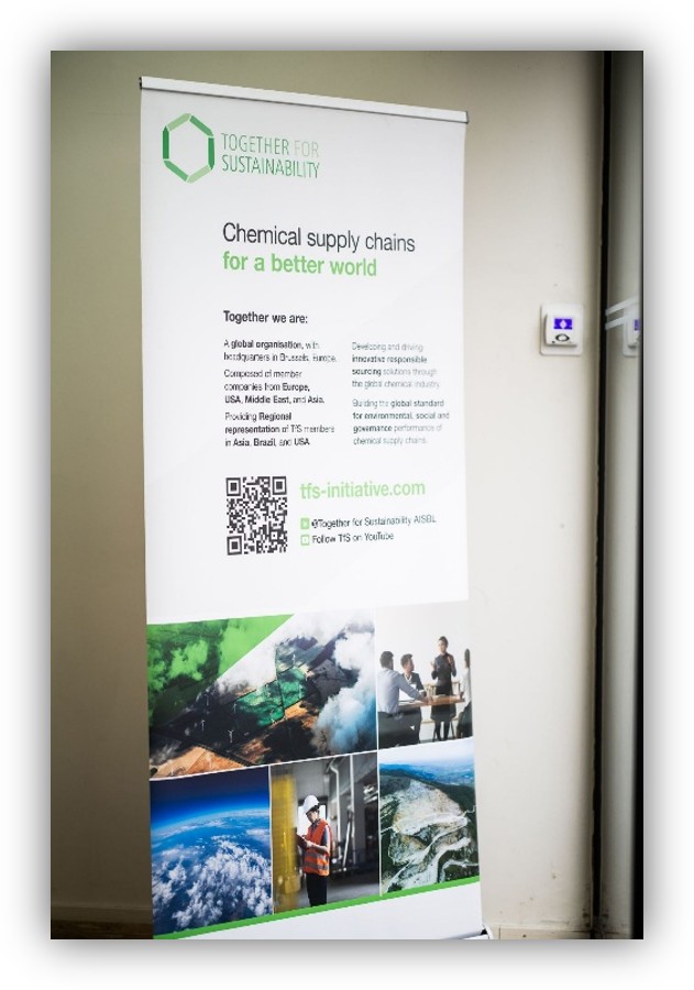 Roll-up informativo de la iniciativa Together for Sustainability sobre cadenas de suministro químicas sostenibles, con texto, logotipo, código QR e imágenes relacionadas con industria y medio ambiente.