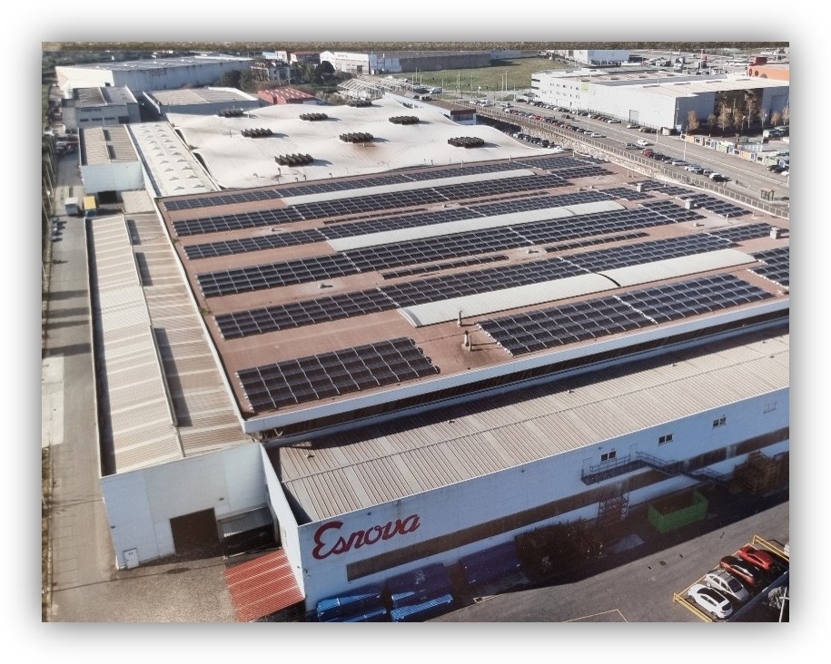 Vista aérea de una nave industrial con paneles solares instalados en la cubierta.