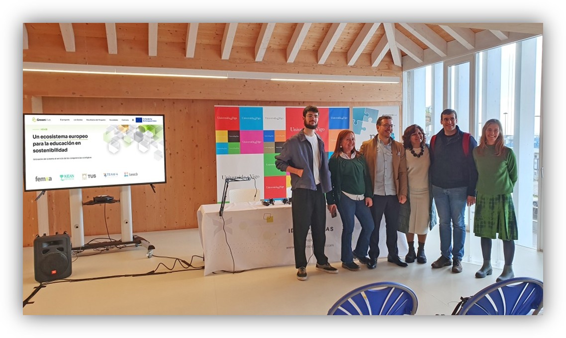 Grupo de personas posando en un evento sobre sostenibilidad en una sala con presentación y materiales informativos.