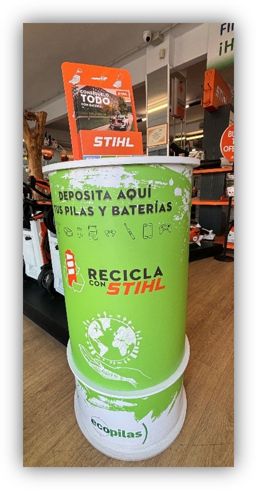 Contenedor verde para reciclaje de pilas y baterías en una tienda, con el mensaje ‘Deposita aquí tus pilas y baterías’.