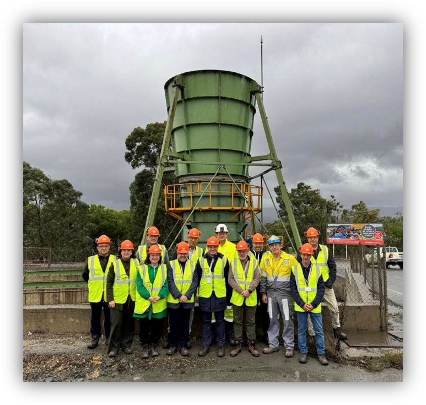 Grupo de personas con equipos de protección individual frente a una instalación industrial de tratamiento de agua.