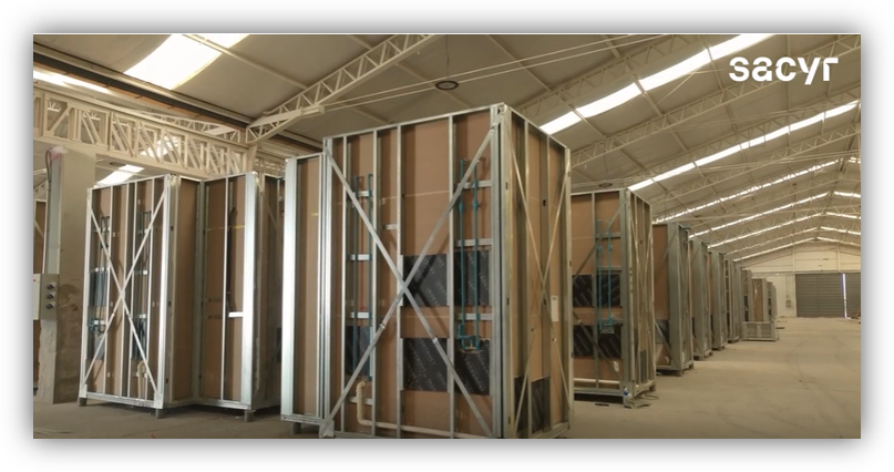 Módulos constructivos industrializados almacenados en una nave de producción para proyectos de edificación.