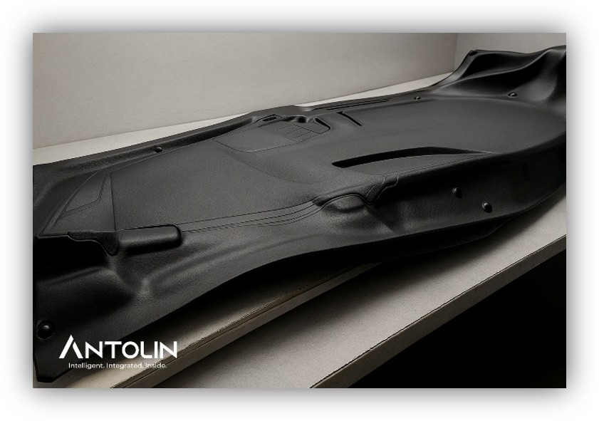 Componente interior de vehículo fabricado por Antolin, colocado sobre una mesa y diseñado con materiales sostenibles para la industria de la automoción.