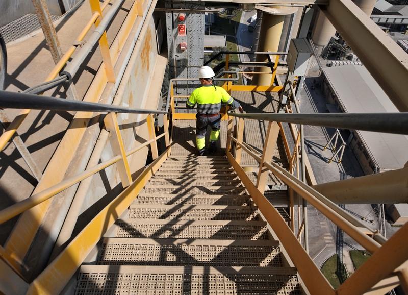 Trabajador en factoría bajando escaleras 