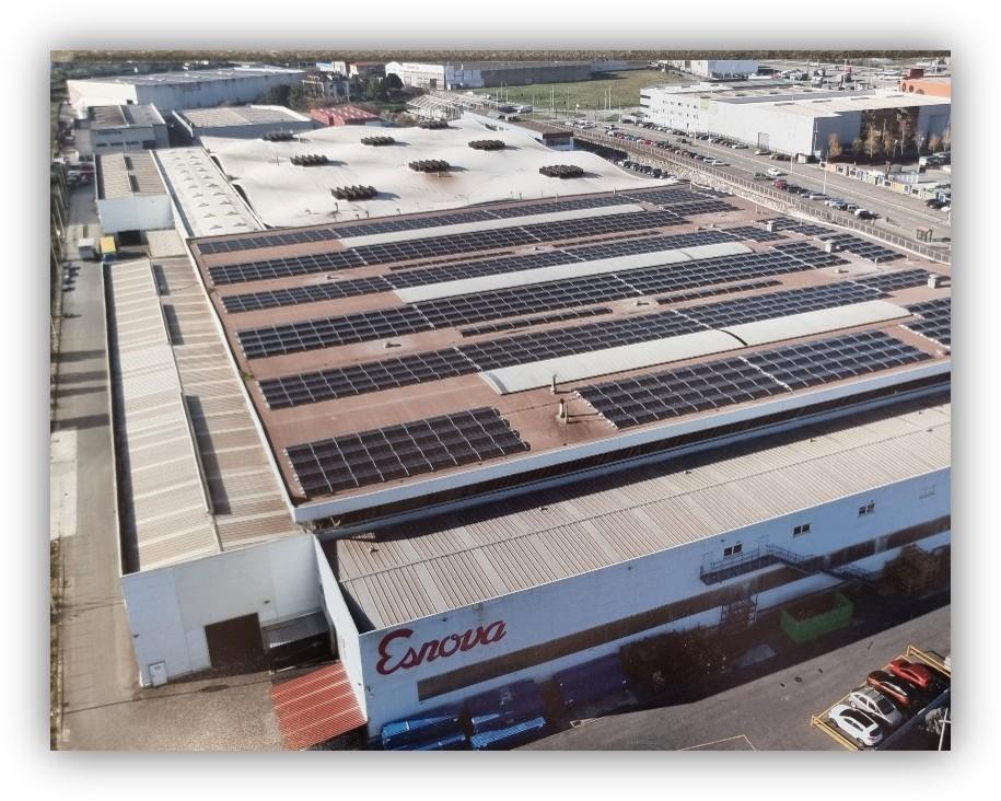 Vista aérea de una nave industrial con paneles solares instalados en la cubierta.