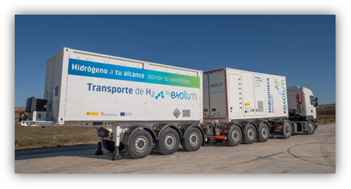 Camión con remolque de transporte de hidrógeno de Exolum, con contenedores blancos rotulados, estacionado en una zona industrial.