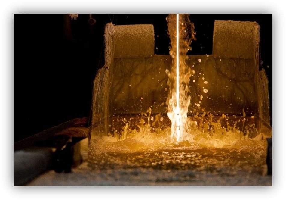 Vertido de metal fundido en un molde industrial, con chispas y material incandescente durante el proceso de fabricación.