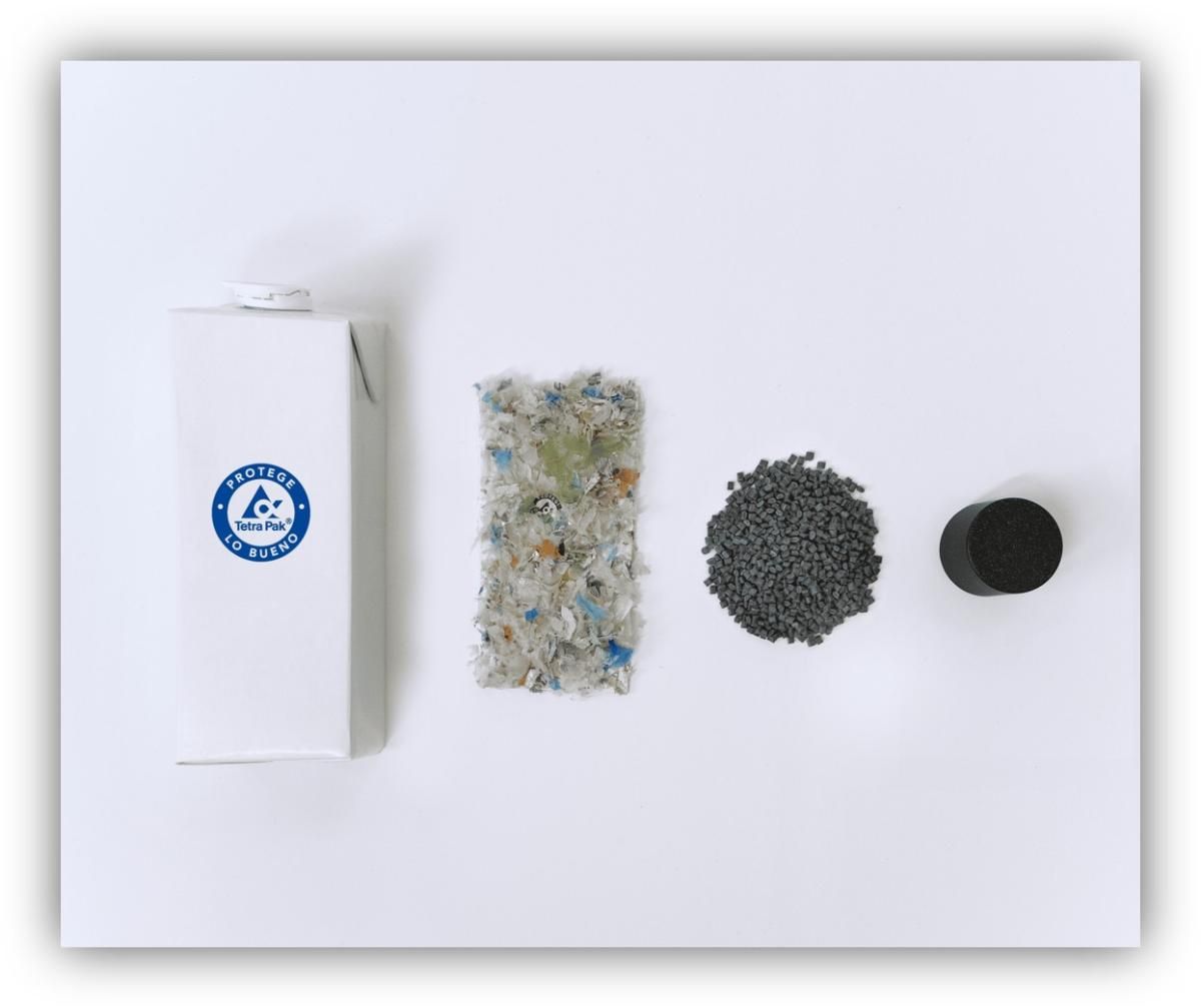 Envase de cartón tipo brik junto a materiales reciclados en distintas fases: fragmentos triturados, granulado y pieza final de plástico.