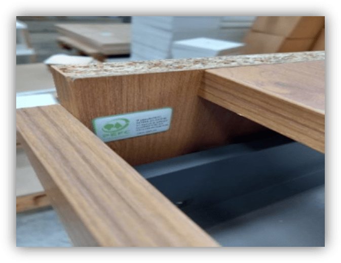 Detalle de una estructura de madera con tablero aglomerado y etiqueta de certificación forestal sostenible.