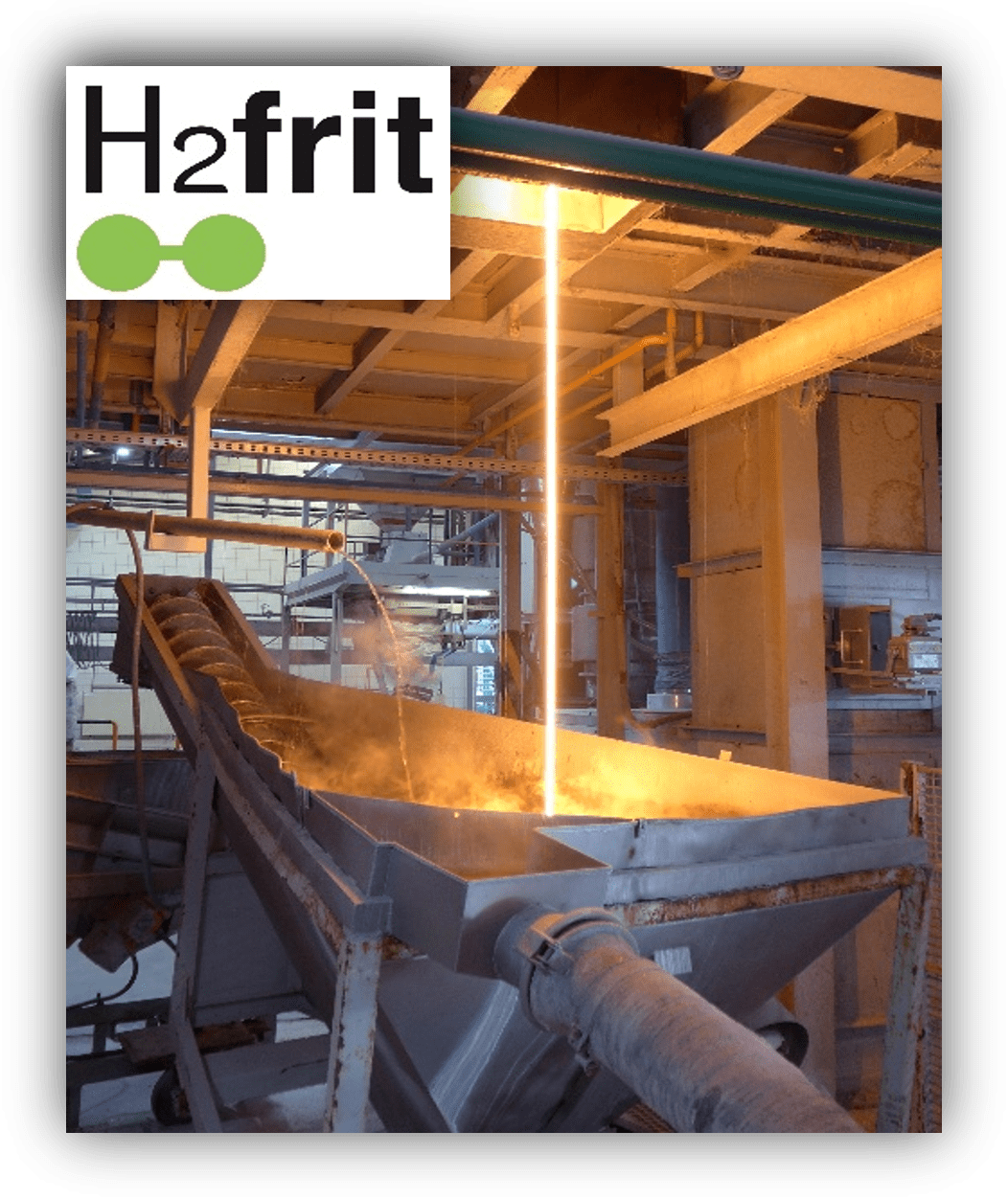 Proceso industrial de fundición con vertido de material incandescente en un canal, en una planta metalúrgica con maquinaria y tuberías.