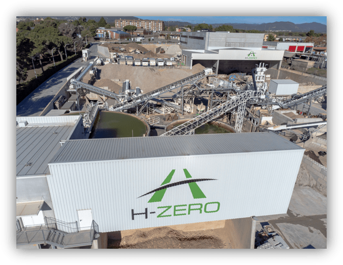 Vista aérea de una planta industrial de reciclaje y tratamiento de materiales, con cintas transportadoras, maquinaria y edificios identificados con la marca H‑ZERO.
