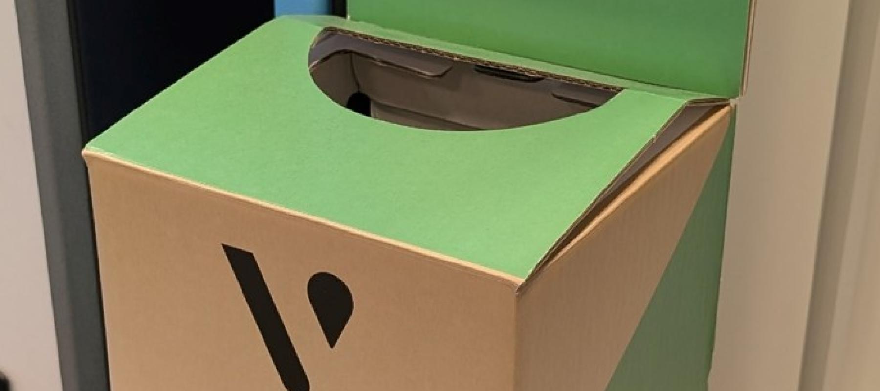 Contenedor verde de reciclaje para productos Vuse, con tapa abierta y mensajes que indican depositar dispositivos usados para su desecho responsable. Incluye logos de Vuse y Ecogec, y la frase ‘Juntos lo hacemos posible’.