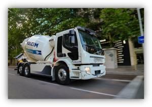 Camión hormigonera de Holcim circulando por una calle con árboles