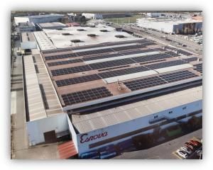 Vista aérea de una nave industrial con paneles solares instalados en la cubierta.