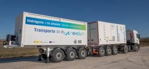 Camión con remolque de transporte de hidrógeno de Exolum, con contenedores blancos rotulados, estacionado en una zona industrial.