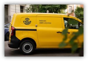 Furgoneta amarilla de reparto con el texto ‘Vehículo 100% eléctrico’ estacionada en una calle urbana.
