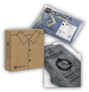 Caja de cartón para prenda de vestir Monza junto a dos prendas empaquetadas en bolsas transparentes reciclables.