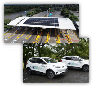 Composición de imágenes con una estación de peaje equipada con paneles solares en la cubierta y dos vehículos eléctricos corporativos estacionados en una zona arbolada.